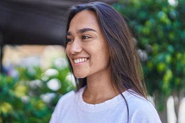 Young beautiful hispanic woman smiling confident looking to the side at street