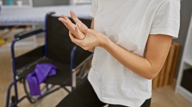 Genç bir kadın rehabilitasyon kliniğinde el egzersizi yapıyor..