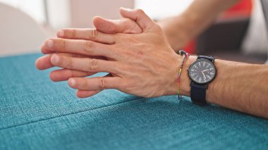 Genç İspanyol adam yemek salonunda el ele oturuyor.