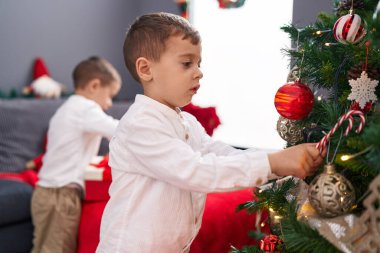 Evdeki Noel ağacını süsleyen sevimli çocuklar.