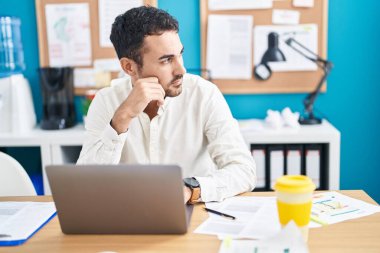 Young hispanic man business worker using laptop working at office