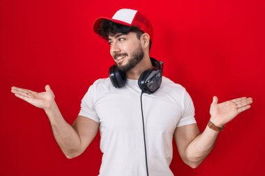 Oyuncuların şapkası ve kulaklığı takan sakallı İspanyol bir adam gülümseyerek avuçlarını açıyor, sunuyor ve reklam karşılaştırması yapıyor ve dengeyi sağlıyor. 