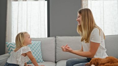 Kafkasyalı rahat anne ve küçük kızı evde güvenle gülücüklerini paylaşıyorlar. Oturma odasındaki kanepede rahatça oturup aile yaşantısını özetliyorlar..