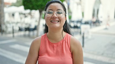 Young chinese woman smiling confident standing at street