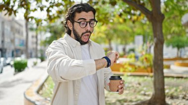 Genç İspanyol adam kahve içiyor. Park 'a şaşırmış gibi bakıyor.