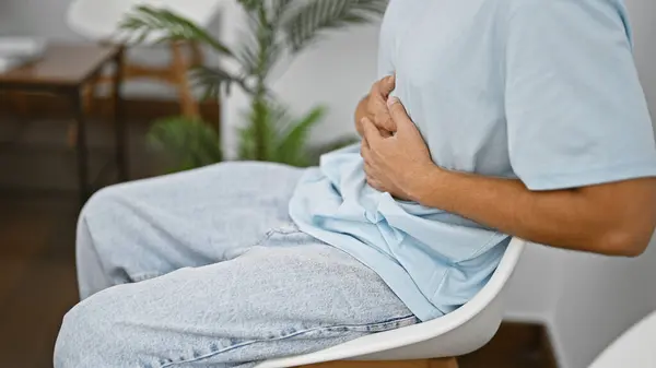 Hispanic Man Stomach Pain Sitting Modern Indoor Waiting Room — Stock Photo, Image