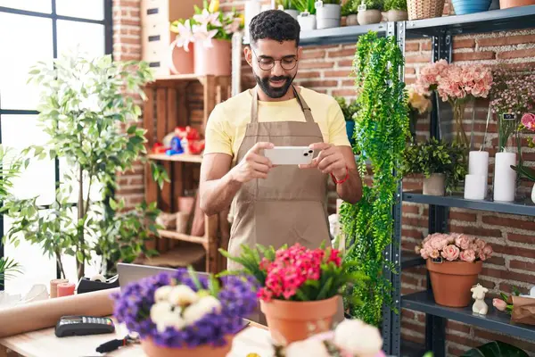 Genç Arap çiçekçi çiçekçiye akıllı telefondan fotoğraf dikmiş.