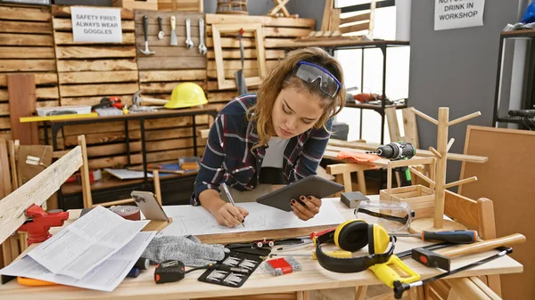 在家具店的家具生意中 年轻的女木匠在触摸板上做笔记 这很吸引人 — 图库照片