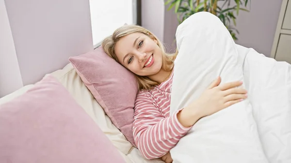 Улыбающаяся Молодая Женщина Уютно Лежит Кровати Розовыми Подушками Предлагая Теплое — стоковое фото
