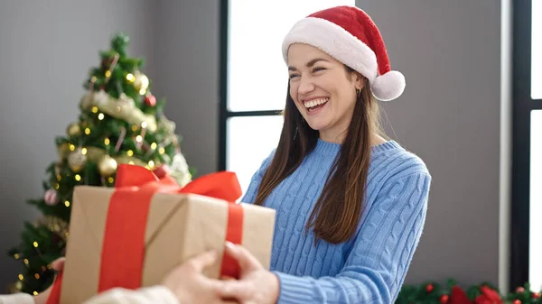 自宅でクリスマスプレゼントを受け取る若い白人女性 — ストック写真
