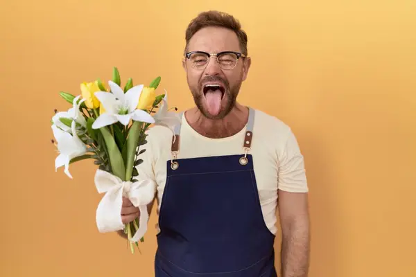 Мужчина Средних Лет Бородой Цветочный Магазин Держа Цветы Высовывая Язык — стоковое фото