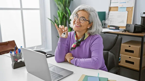 Mature Smiling Woman Holding Key Modern Office Showcasing Business Real — Stock Photo, Image