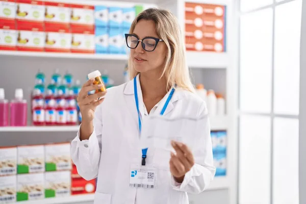 Jonge Blonde Vrouw Apotheker Holding Pillen Fles Lezen Recept Apotheek — Stockfoto