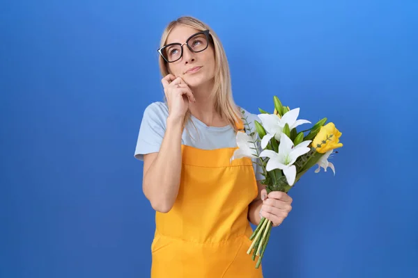 Çiçekçi Önlüğü Giymiş Eli Çenesinde Çiçeklerle Soru Soran Beyaz Bir — Stok fotoğraf