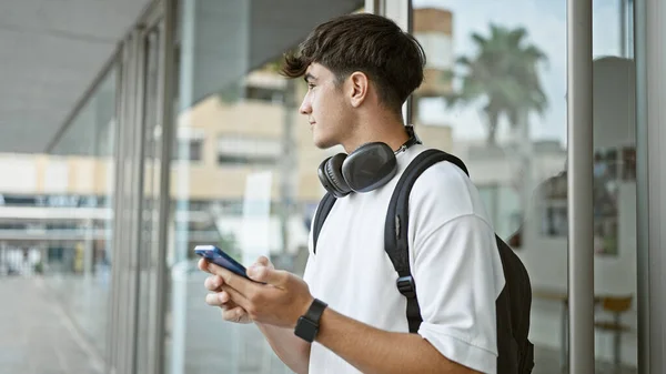 Mladý Hispánský Teenager Student Nosí Sluchátka Batoh Pomocí Smartphone Univerzitě — Stock fotografie