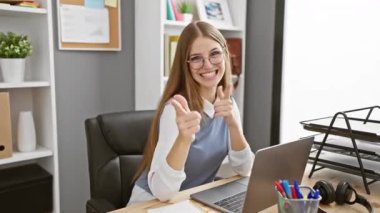 Güçlü ve formda sarışın iş adamı kaslarını gösteriyor, kendine güvenen genç bir kadının ilham verici portresi ofiste fitness yaşam tarzını kucaklıyor.