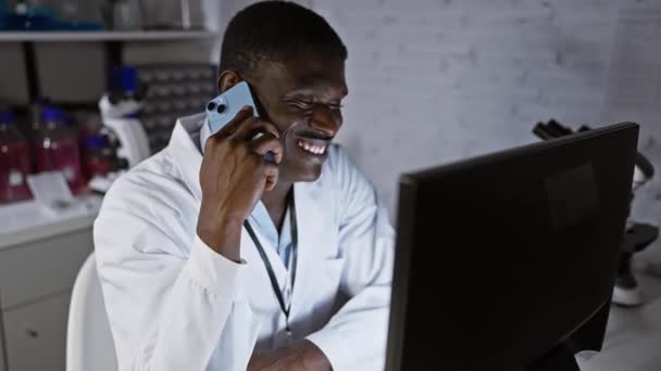 陽気なアフリカ人男性 医療専門家 実験室でスマートフォンで話す — ストック動画
