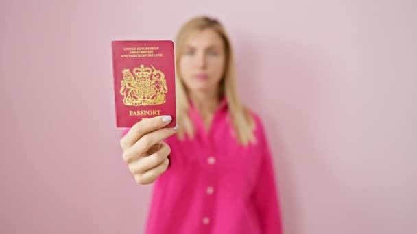 自信的金发女人拿着北爱尔兰护照 手牵着手在粉色孤立的背景上做停止动作 表示严肃的辩护 — 图库视频影像