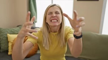 Gömlek giyen genç sarışın kadın öfkeyle bağırıyor, elleri boğmaya çalışıyor, eve bağırıyor.