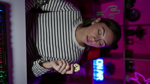 Молодая Женщина Держит Помещении Монету Неоновым Освещением — стоковое видео