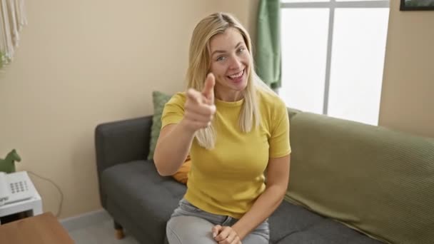아름답고 행복한 금발은 집에서 온다제스처 티셔츠를 그녀의 미소와 따뜻한 환영을 — 비디오