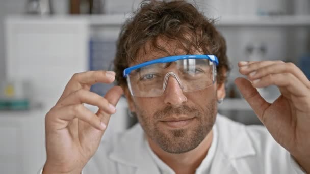 一个长着绿眼睛 留着胡子 戴着安全眼镜的英俊的惊慌男子在实验室里摆出一副样子 — 图库视频影像