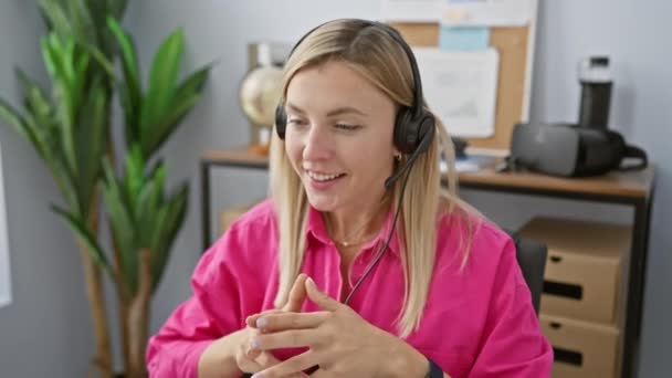Una Joven Profesional Una Camisa Rosa Con Auriculares Comunica Entorno — Vídeos de Stock