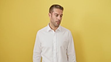 Umutsuzluk içinde göğüs göğüse çarpışan cahil İspanyol genç adam aptalca hatasını fark eder. Hafızası zayıflar! Sarı arka planda izole edilmiş, yakışıklı yüzüne kazınmış pişmanlık..