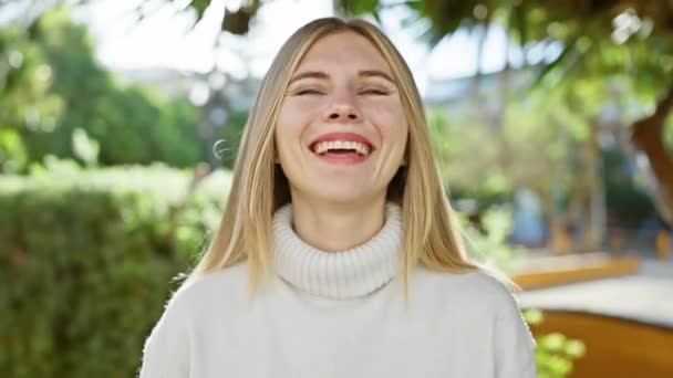 一位金发碧眼 面带微笑的女人 在户外享受着绿意盎然的阳光 — 图库视频影像