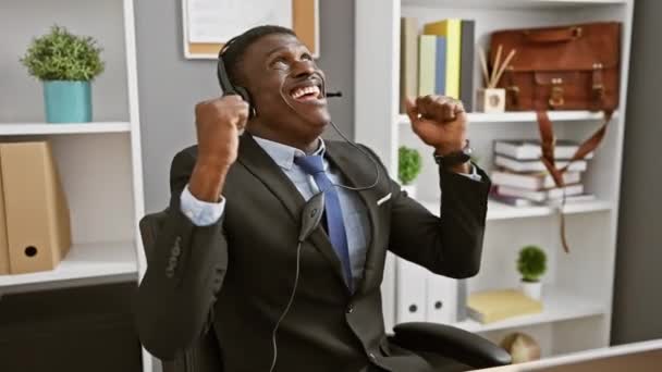Homme Noir Jubilant Costume Avec Écouteurs Célèbre Succès Son Bureau — Video