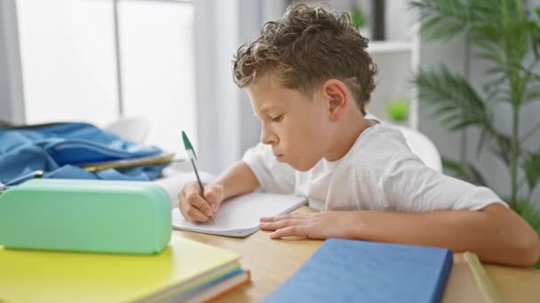 Adorable Blond Boy Student Focused Learning Taking Notes Sitting Desk — Stock Video