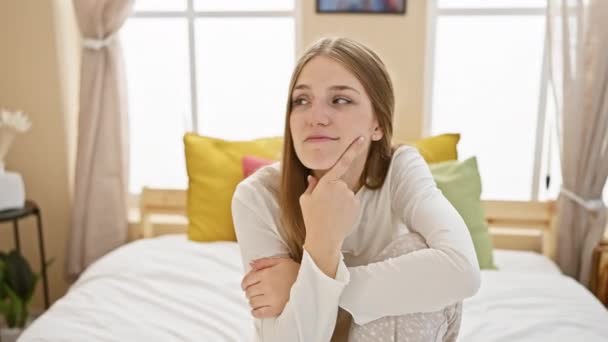 Προσεκτική Νεαρή Ξανθιά Γυναίκα Φορώντας Πιτζάμες Κάθεται Στο Κρεβάτι Πηγούνι — Αρχείο Βίντεο