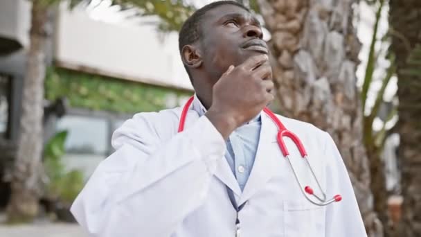 在热带城市环境中 一位神智清醒的非洲男医生 带着听诊器 身穿白色外套 — 图库视频影像