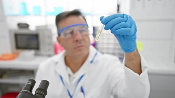 Een Gefocuste Man Onderzoekt Een Reageerbuis Een Laboratoriumomgeving Toont Professionaliteit — Stockvideo