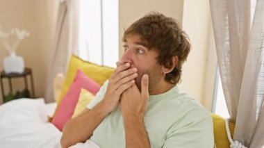 Kafkasyalı genç bir adam pijama giymiş elleriyle ağzını kapatıyor yatak odasındaki gizli hatayı fark ediyor ve yüzüne korku kazınıyor.