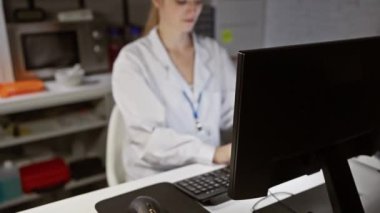 Laboratuvar önlüklü, kederli genç bir kadın geç saatlere kadar klinikte çalışırken boynuna masaj yapıyor..