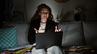 Genç, profesyonel bir kadın evdeki bir video görüşmesinde uzaktan kumandalı bilgisayarını ve belgelerini kullanmış..