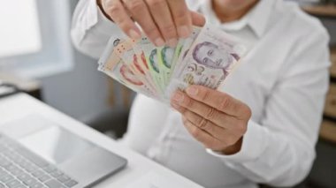 Singapur para birimini elinde tutan orta yaşlı bir adam, finans ve iş konularını çağrıştırıyor.