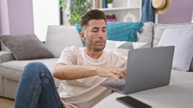 Neşeli, İspanyol asıllı genç adam evde mutlu bir online seanstan sonra dizüstü bilgisayarını kapatıyor. Pozitif enerji yayıyor.