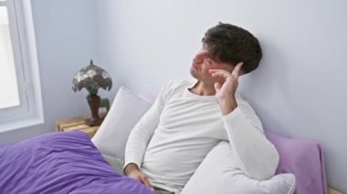 Düşünceli, genç, İspanyol bir adam, yatak odasında pijamalarıyla yatıyor. Ciddi bir yüz ifadesi ve çene üzerinde eli ile, o yoğun bir kafa karıştırıcı bir fikir üzerinde düşünüyor..