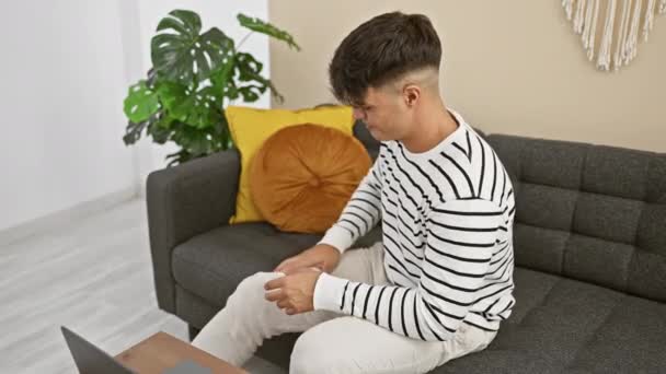Unruhiger Junger Hispanischer Mann Sitzt Auf Dem Bequemen Heimischen Sofa — Stockvideo