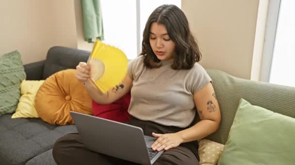 Uma Jovem Hispânica Esfria Com Ventilador Amarelo Enquanto Usa Laptop — Vídeo de Stock