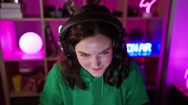 Young Woman Enjoys Music Headphones Vibrant Neon Lit Gaming Room — Stock Video
