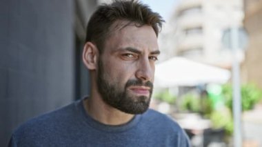 Sokakta ciddi bir ifadeyle duran İspanyol genç adam.