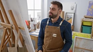 Gülümseyen genç bir İspanyol 'un portresi, resim stüdyosunun ortasında kendinden emin bir şekilde oturuyor.