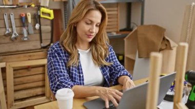 Neşeli, kendine güveni tam Latin bir kadın başarılı, ışıl ışıl yüzü var. Marangoz masasında oturuyor ve eliyle dostça bir 