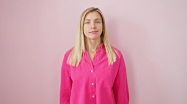 Güzel, genç, sarışın bir kadın pembe, soyutlanmış arka planda duruyor, el kulağına samimi bir şekilde dinliyor. İşitme engelliliğiyle yüzleşiyor, çabalarına rağmen sevinçlerini dile getiriyor.