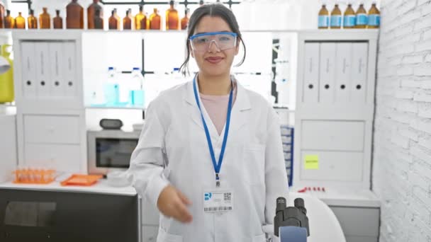 Latynoska Kobieta Naukowiec Uśmiechnięta Fartuchu Laboratoryjnym Goglami Nowoczesnym Laboratorium Pomieszczeniach — Wideo stockowe