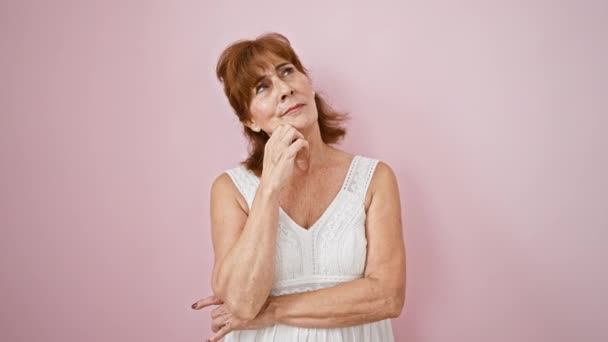 Pensive Middle Age Woman Dress Pink Wall Background Hand Chin — Stock Video