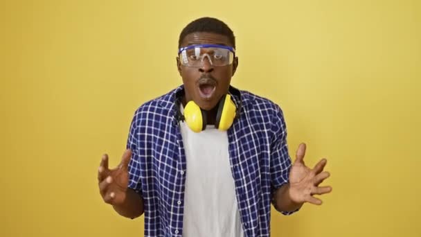 Astonished African American Man Safety Glasses Open Mouth Yellow Background — Stock Video